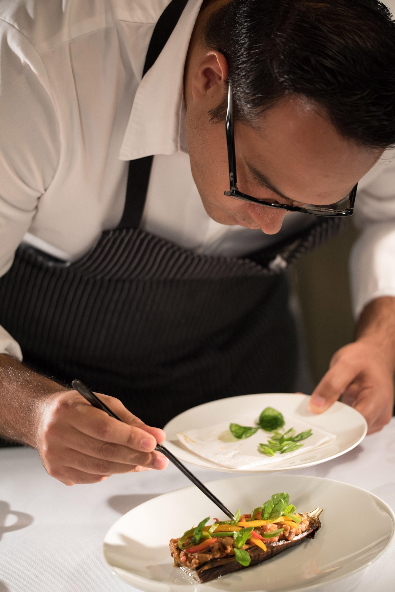 restaurateur chef cuisinier qui dresse une assiette